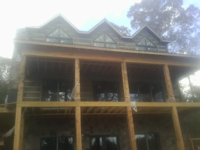 Dormers and porch framing on a large log home under construction — Roof Coating work by our crew in Dilliner
